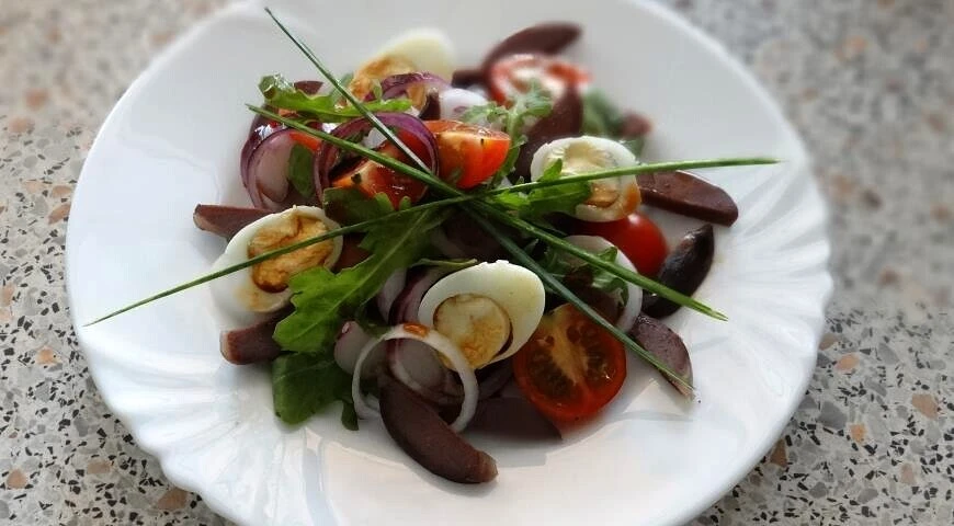 Salad with duck stomachs, arugula and cherry tomatoes