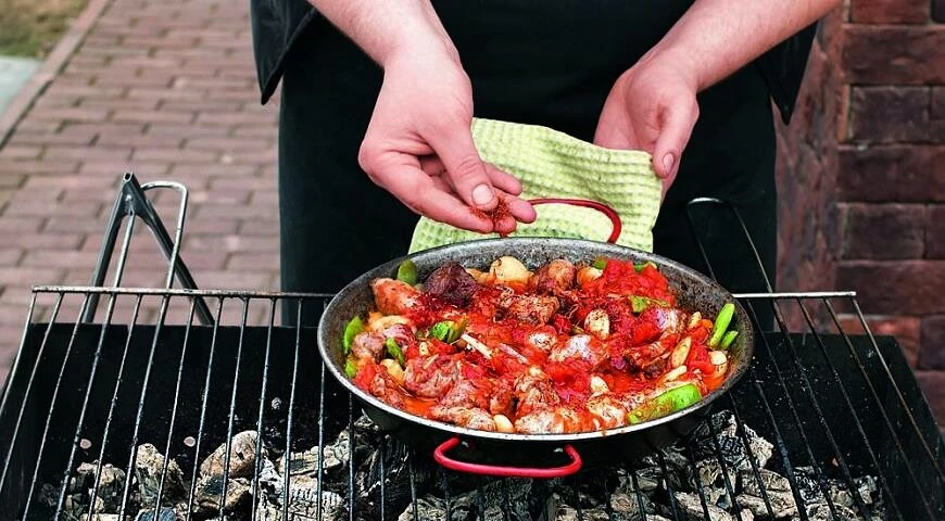 Paella au charbon de bois avec saucisses et trois types de viande