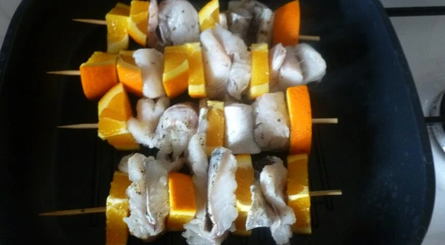 Fish with orange on skewers