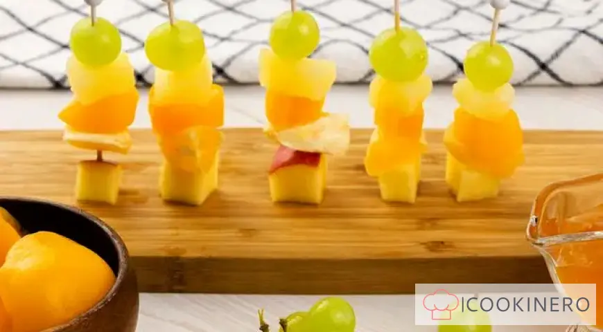 Canapé aux fruits avec raisins, pommes, orange et ananas