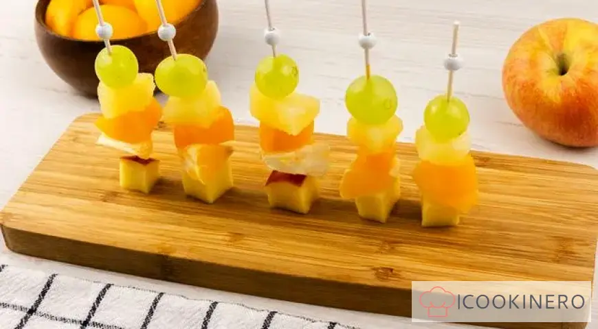 Fruchtcanapé mit Trauben, Äpfeln, Orangen und Ananas