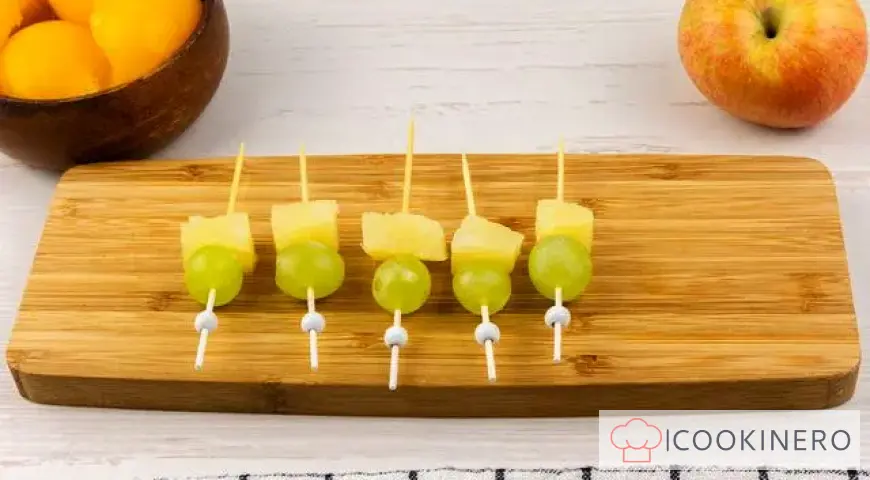 Fruchtcanapé mit Trauben, Äpfeln, Orangen und Ananas