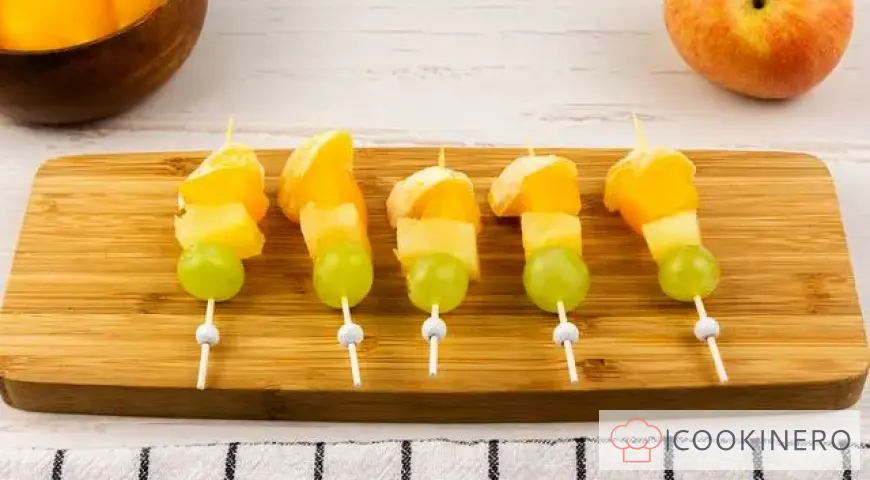 Fruchtcanapé mit Trauben, Äpfeln, Orangen und Ananas