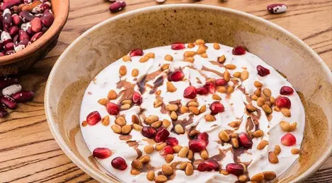 Hausgemachte Matsoni mit Limettensaft, Pinienkernen, Granatapfelkernen und Granatapfelsauce