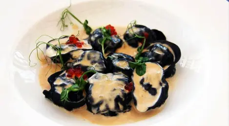 Holzkohleknödel aus sibirischer Fischnelma mit Coho-Lachskaviar in heißem Kaymak