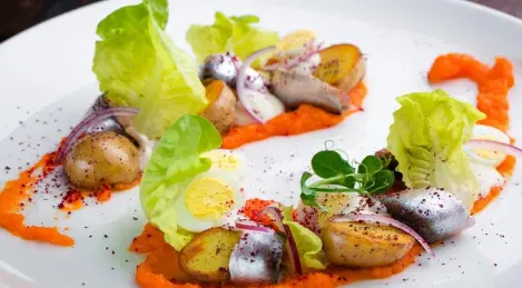 Sprat with potatoes on carrot puree