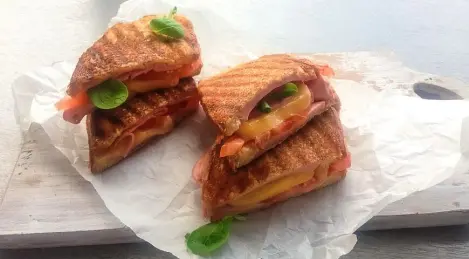 Fried sandwiches with ham, cheese and tomatoes