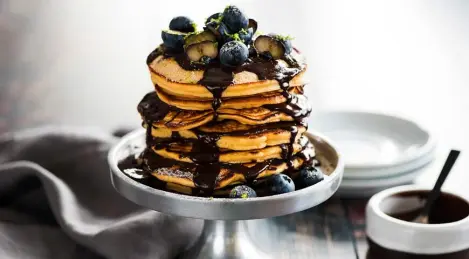 Pancake cake with blueberries and chocolate