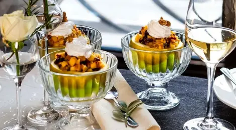 Apple baked with whipped cream and spiced peanuts
