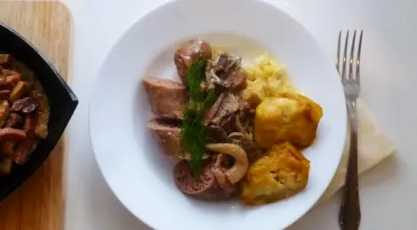 Salchichas de cerdo con salsa de champiñones y puré de apio