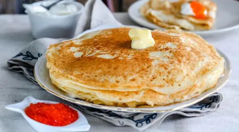 Thick pancakes in milk with caviar