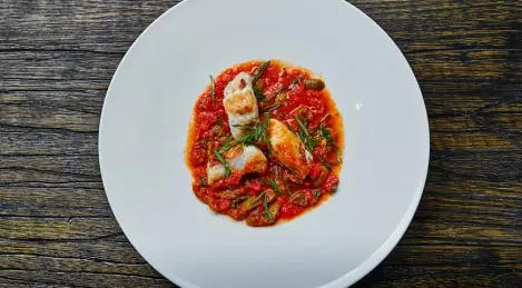 Congrio fish baked with tomatoes