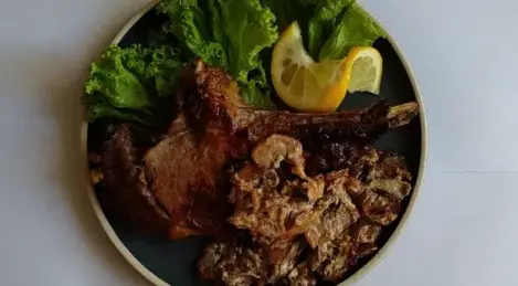 Appetizing bone-in steak with mushrooms in a creamy sauce
