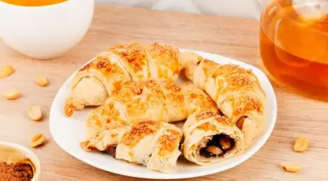 Croissants with condensed milk, cocoa and peanuts